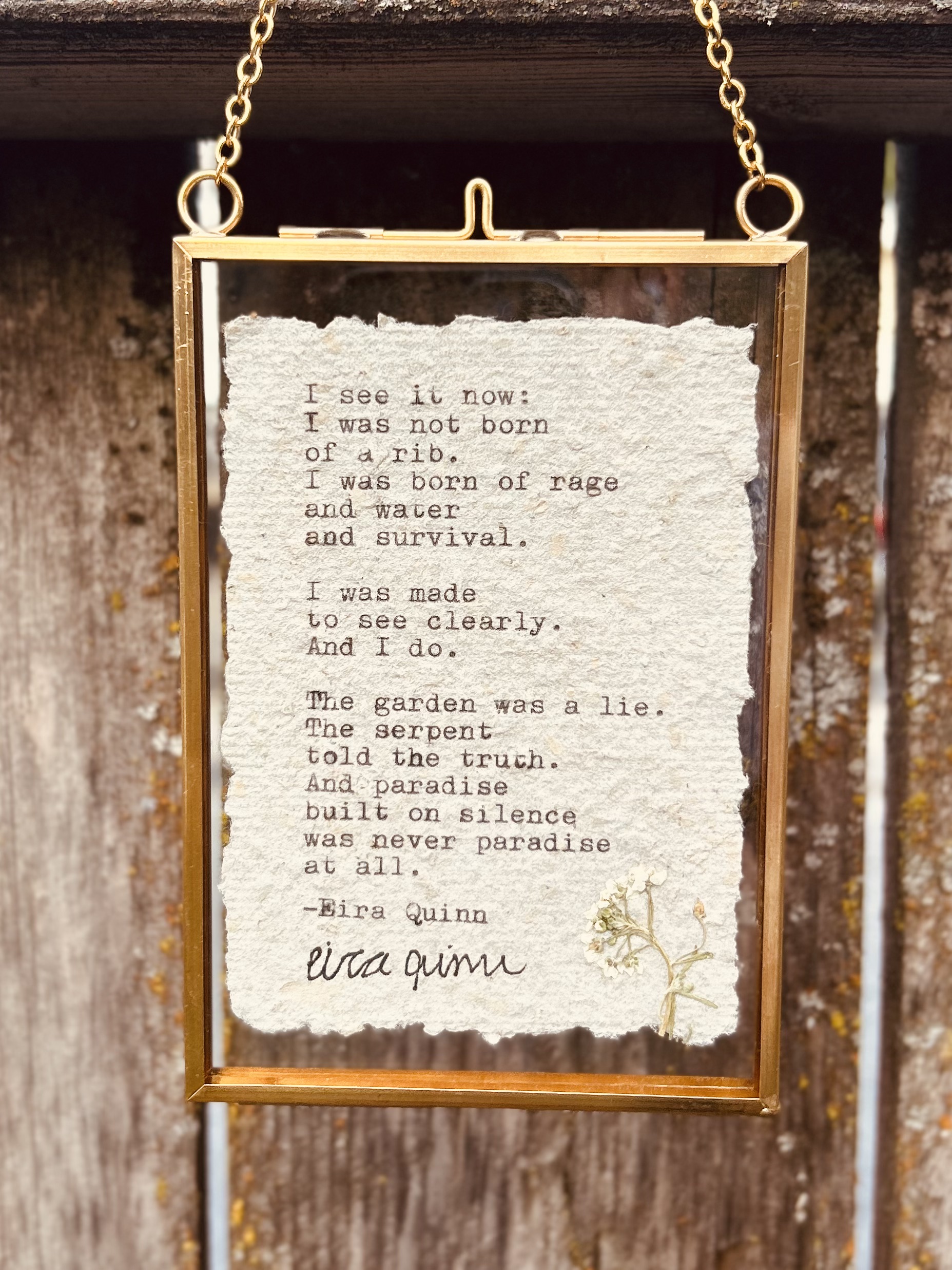 "Made to See Clearly" hand-typed on A7 paper with a pressed flower, in a hanging glass frame